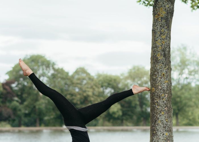 Woman performing a balancing yoga pose in nature.